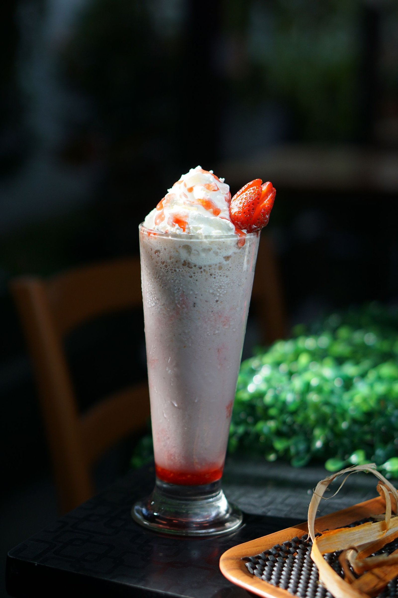 A delicious strawberry milkshake topped with whipped cream and fresh fruit.